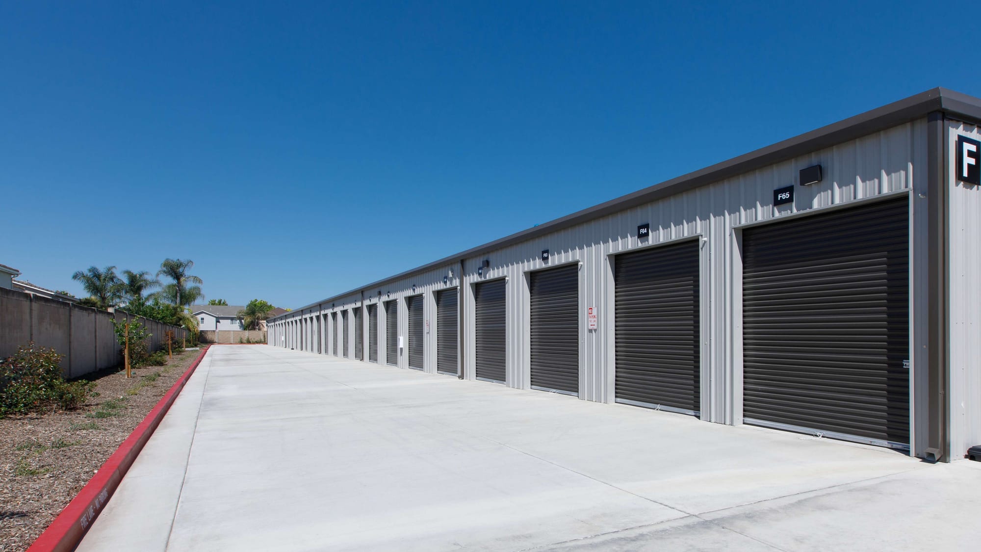 Building F's long row of drive-up storage units at Manteca Storage, with a marked fire lane alongside