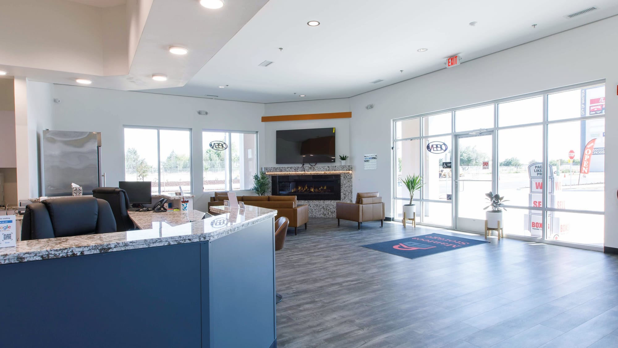 The customer lounge inside Manteca Storage's office, with leather seating, a fireplace, and floor-to-ceiling windows